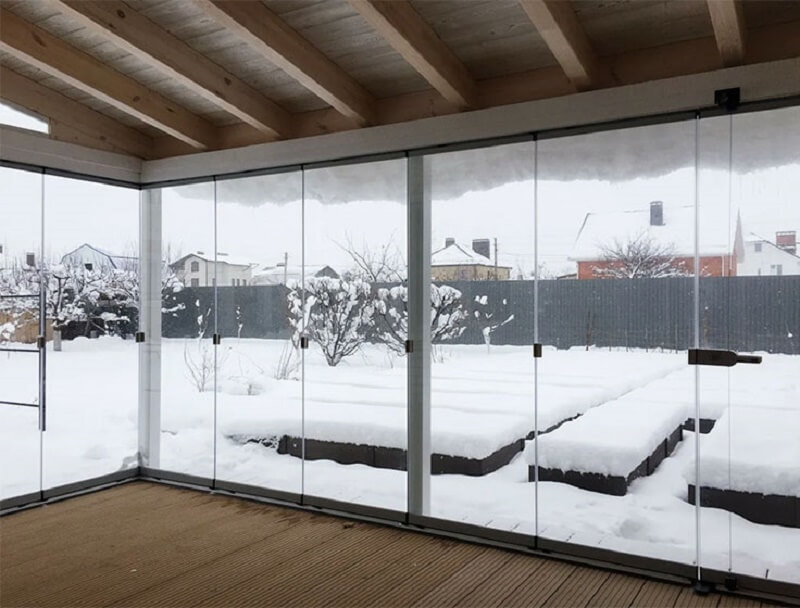 Стеклянная беседка легко превращается в открытую даже зимой