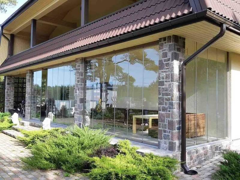 Остекление террасы коттеджа в сочетании с разной отделкой фасадов